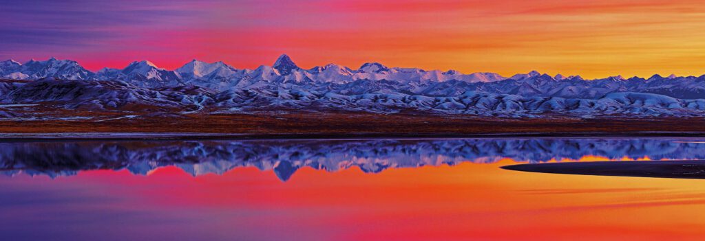 Info Shymkent - Peaks of Tian Shan with Khan Tengri in the center are reflected in the morning light in Tuzkol Lake (Photo: F. Kabdykairov)