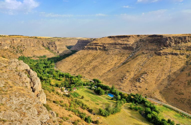 Info Shymkent - The Mashat canyon forms with trees and meadows on the floor of the canyon a green line through rocky terrain