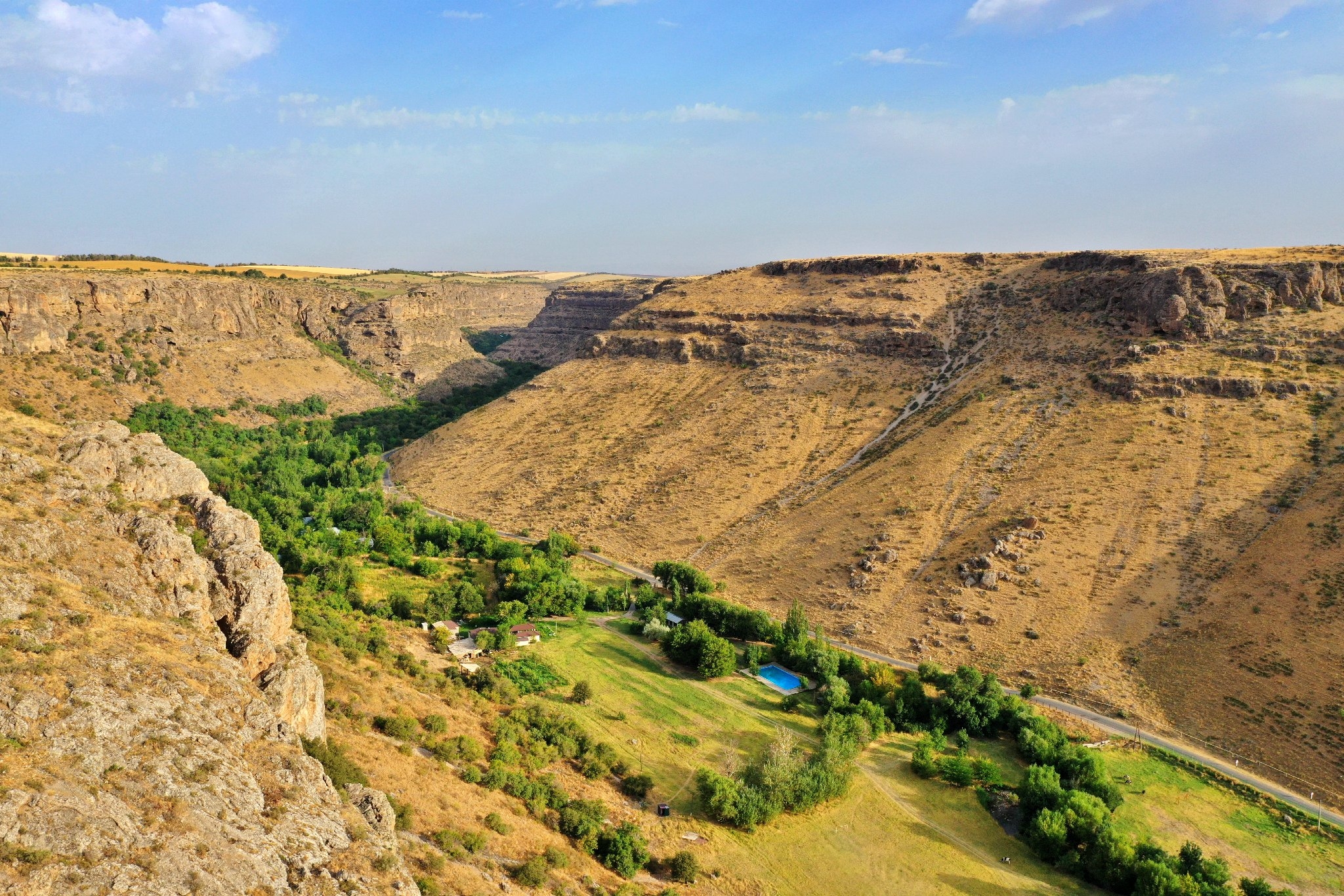 Info Shymkent - The Mashat canyon forms with trees and meadows on the floor of the canyon a green line through rocky terrain